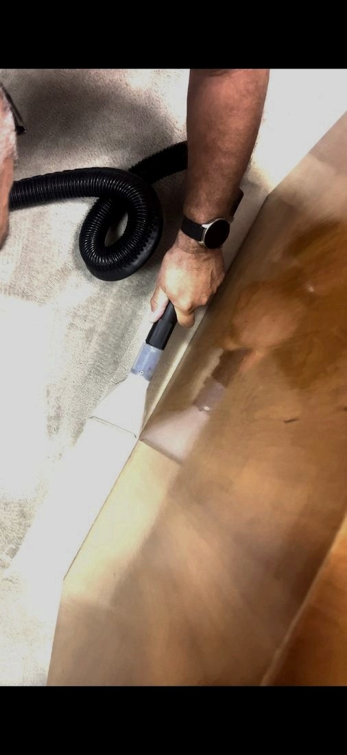 Καθαρισμός άκρης μοκέτας δίπλα σε ξύλινη επιφάνεια, με μηχάνημα extraction